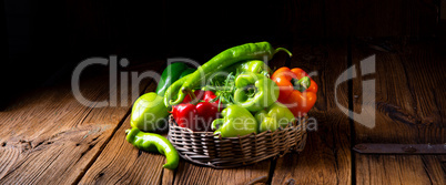 various harvested peppers and hot peppers in basket