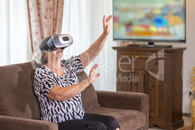 Senior woman with virtual headset or 3d glasses playing