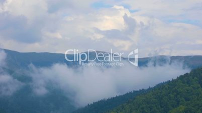 Clouds moving over mountains and village in summer day