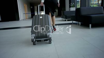Business woman walking with a wheeled bag