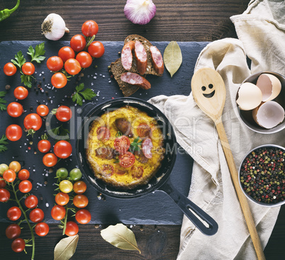 round frying pan with fried omelette, whipped eggs with cherry t