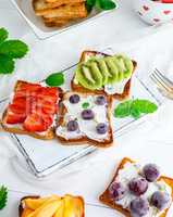 toasts with soft cheese, strawberries, kiwi, cherries and bluebe