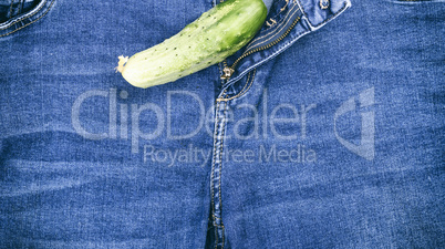 green fresh cucumber lay on blue jeans