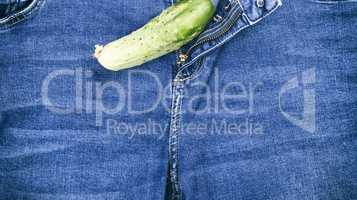 green fresh cucumber lay on blue jeans