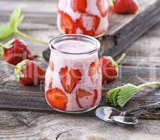 ripe red strawberry and two glass jars of smoothies