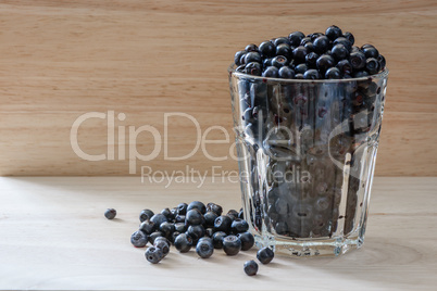 Blueberries in a glass with scattered berries. Vitamin charge for the day