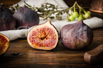 Ripe seasonal figs on wooden table with sliced one
