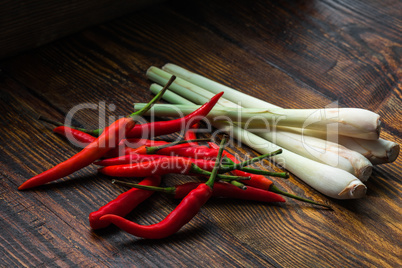 Pile of thai Bird's Eye Chilis with lemongrass on a old wooden table