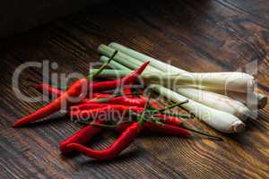 Pile of thai Bird's Eye Chilis with lemongrass on a old wooden table