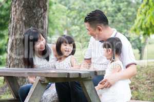 Asian family outdoors with empty table space.