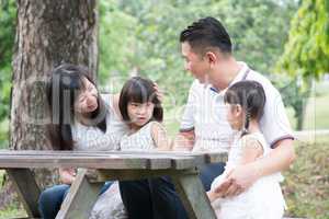 Asian family outdoors fun with empty table space.