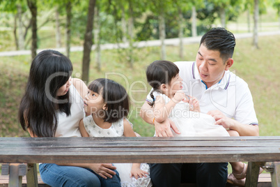 Asian family bonding outdoors with empty table space.