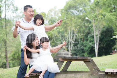Happy Asian family at outdoor with empty table space.