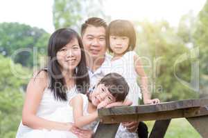 Happy Asian family having fun outdoor with empty table space.
