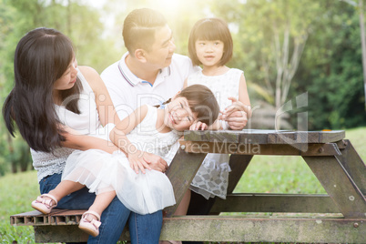 Happy Asian family bonding outdoor with empty table space.