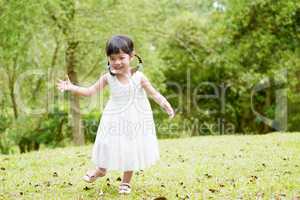 Little Asian girl running at park