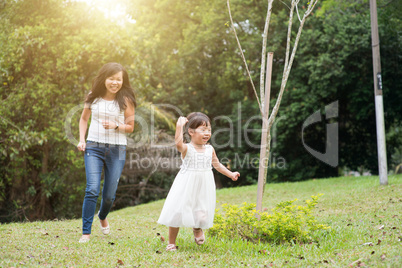 Mother and little girl running outdoors