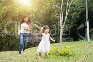 Mother and little girl running outdoors