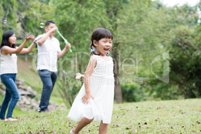 Asian family blowing soap bubbles