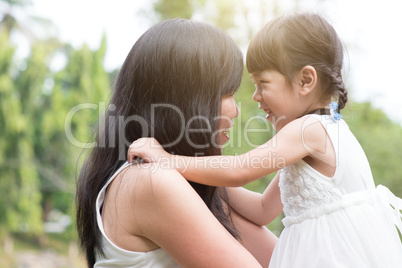 Asian mother and daughter outdoors.