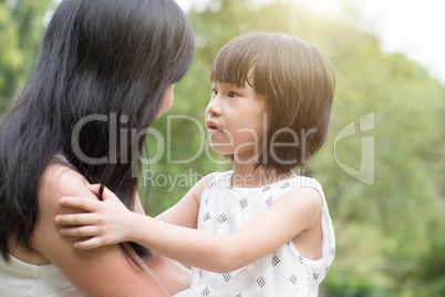Asian mother and daughter bonding outdoors.