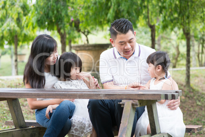 Asian family at outdoors with empty table space.