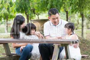 Asian family at outdoors with empty table space.