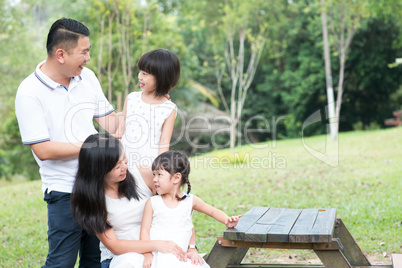 Asian family portrait with empty table space.