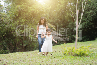 Mother and little girl chasing outdoors