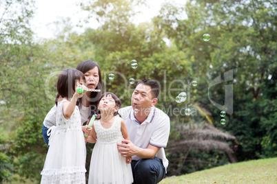 Family blowing soap bubbles