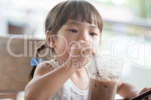 Little child drinking at cafe