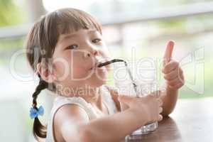 Young kid drinking at cafe