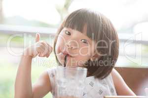 Asian Child drinking at cafe