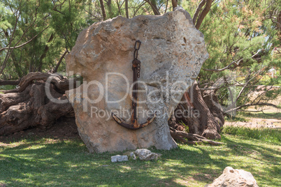 Old rusted ship's anchor on a stone.