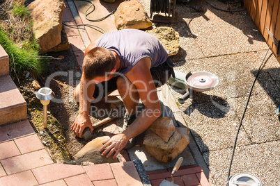 Man building a sandstone wall