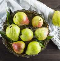 ripe green pears in an iron plate on a brown wooden table