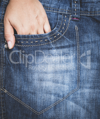 left hand stuck in the front pocket of blue jeans, full frame