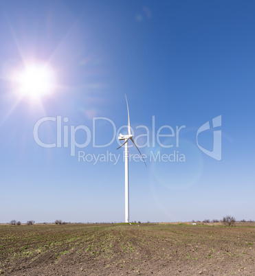 windmill in the middle of the field in the rays