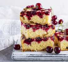 baked square pieces of a biscuit pie with cherries