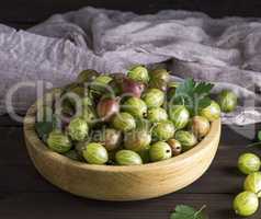 ripe green gooseberry in a wooden bowl