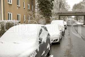 Parked cars in the street in winter