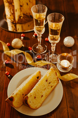 Sliced italian panettone, sparkling wine and decorations over a