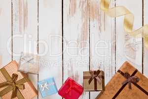 Christmas presents and golden ribbon over a rustic wooden table