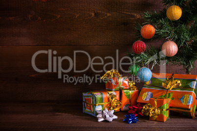 Many Christmas presents under the tree on plank background