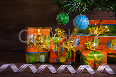 Many Christmas presents under the tree with decorations and ribb