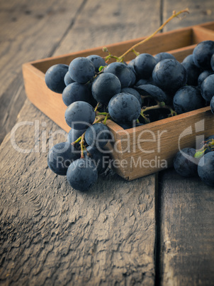 Tasty blue grapes in a wooden box