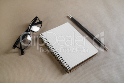 Notebook, glasses, pencil