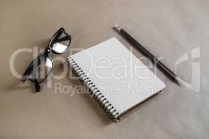 Notebook, glasses, pencil