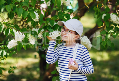 Child smelling white lilac