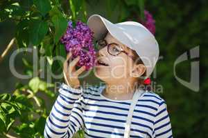 Child smelling lilac